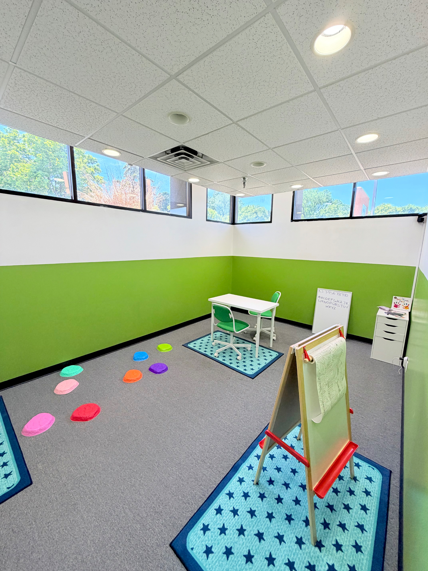 Spectrum Roots 1:1 therapy room with stepping stones, easel, and a learning table